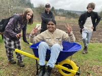 Nanaimo FoodShare participants at a field playing with a wheelbarrow