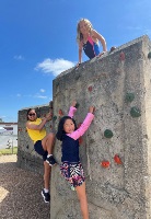 Youth leader and two children climbing a climbing wall