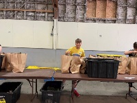 A leader in training helps bag food